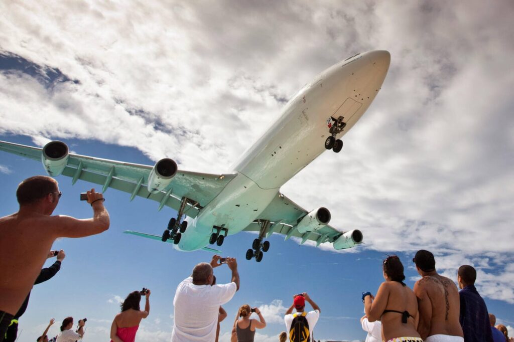 A plane flying low over Maho Beach during a Full Island Tour in St. Maarten.