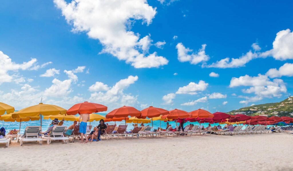 Colorful umbrellas and clear water at Mullet Bay Beach on the Beach Hopping Tour in St. Maarten.
